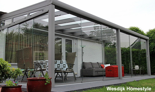 Veranda tuinkamer met glazen schuifwanden en composiet terrasvlonder.