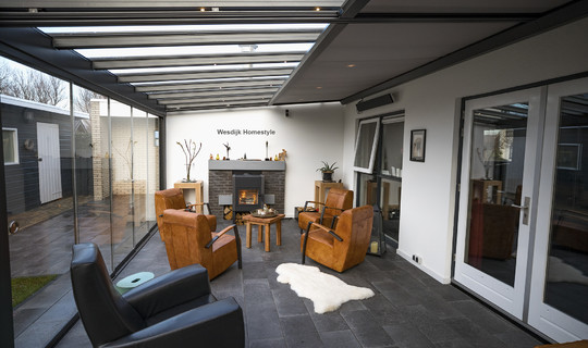 Tuinkamer met zonwering, geïntegreerde LED verlichting en glazen schuifwanden. 